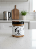 Barley Moon Botanicals Apple of My Hive creamed honey with apple pie spice in a glass jar on a kitchen counter