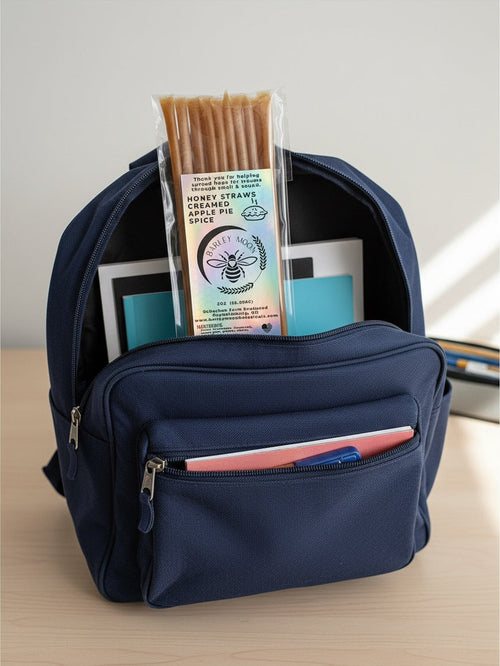Barley Moon Botanicals Apple Pie Spice creamed honey straws in a clear pack inside a navy blue school backpack.