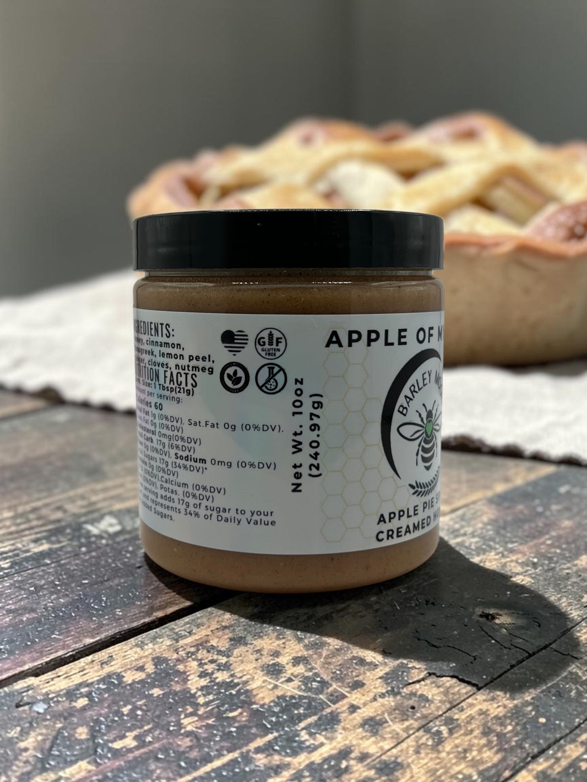 Barley Moon Botanicals Apple of My Hive creamed honey jar with apple pie spice label on a rustic wooden table