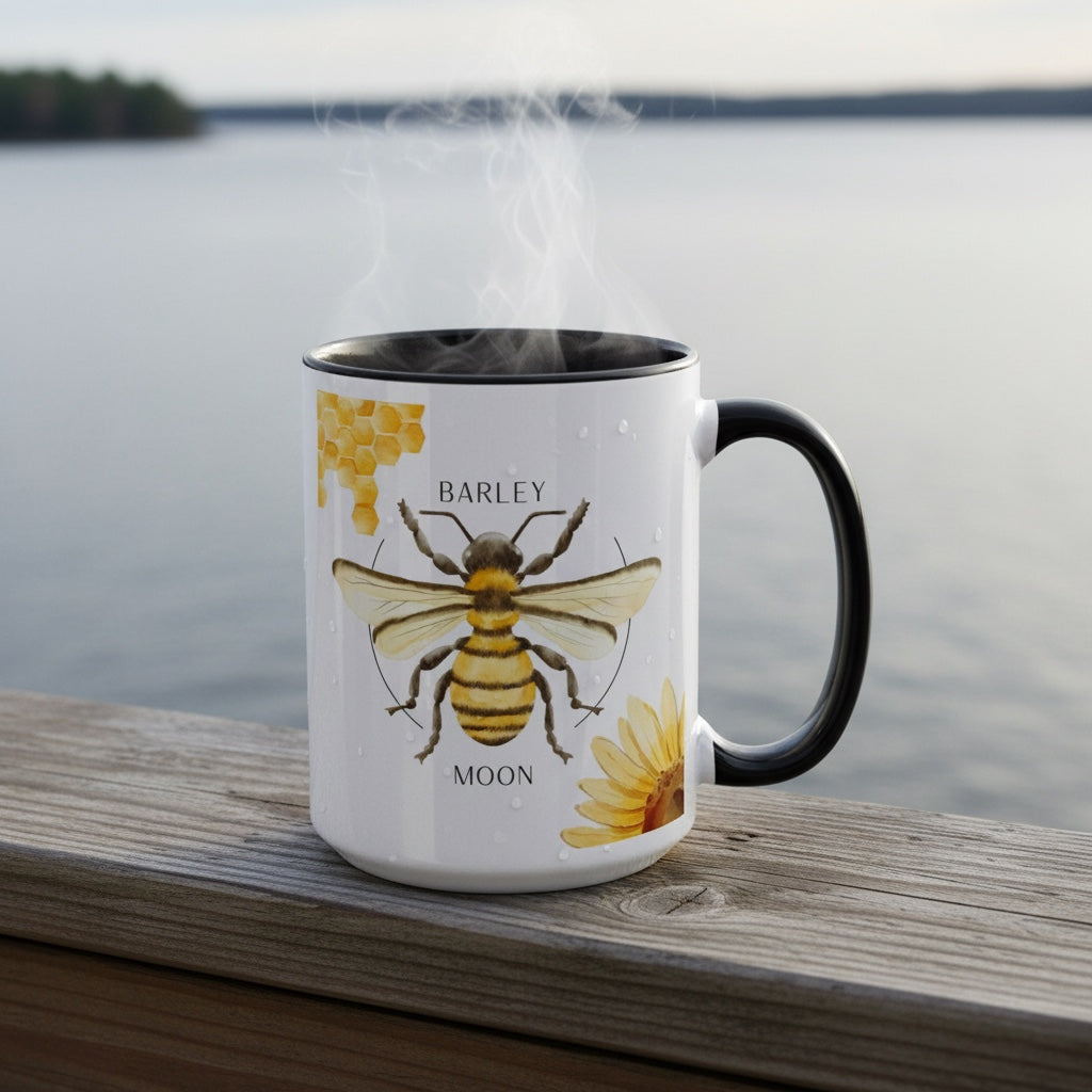 Barley Moon Botanicals 15oz ceramic mug with bee and flower design, black handle and interior, steaming on a deck.