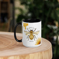 Barley Moon Botanicals 15oz ceramic mug with a bee and flower design, featuring a black handle and black interior.