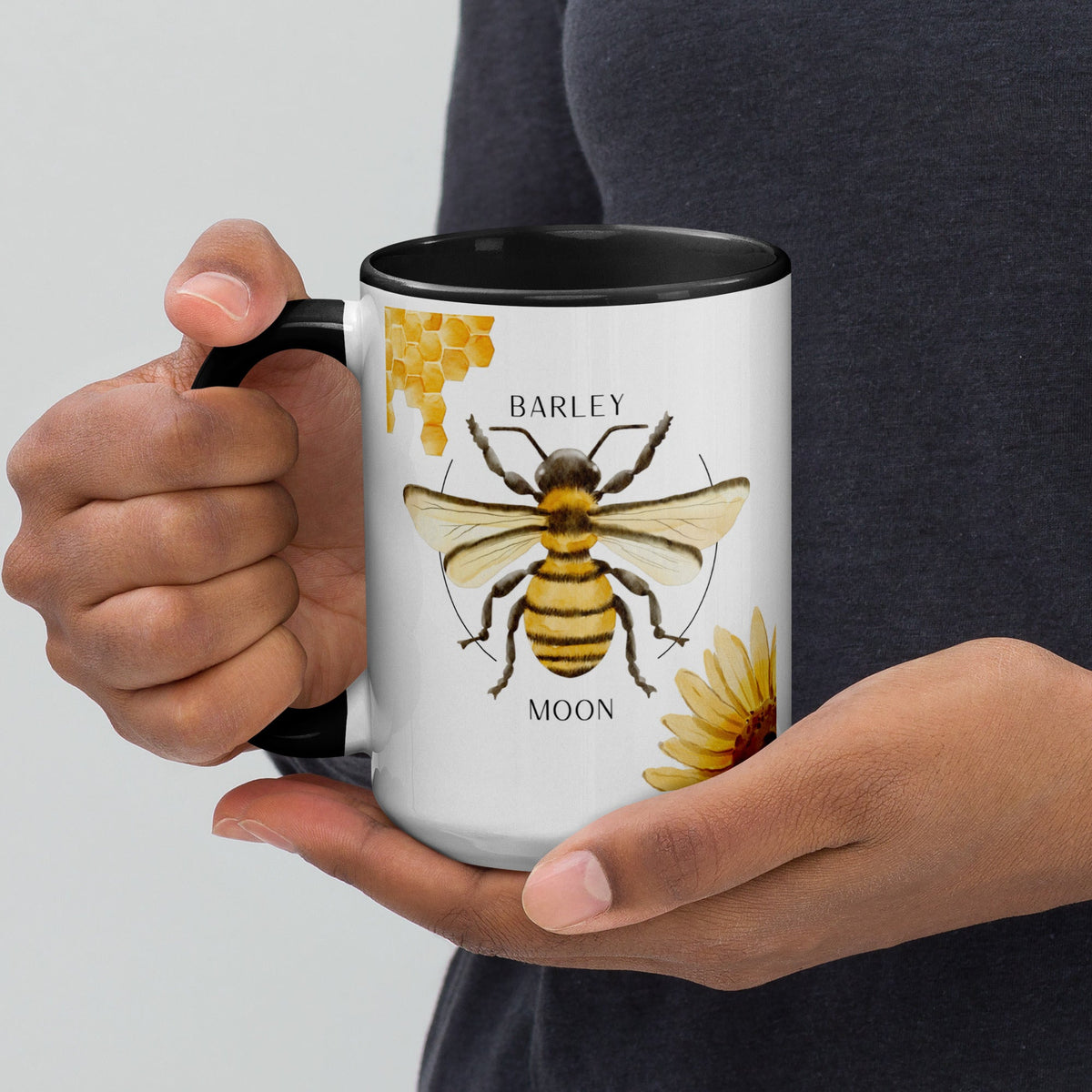 Barley Moon Botanicals 15oz ceramic mug with bee and flower design, featuring a black handle and interior.