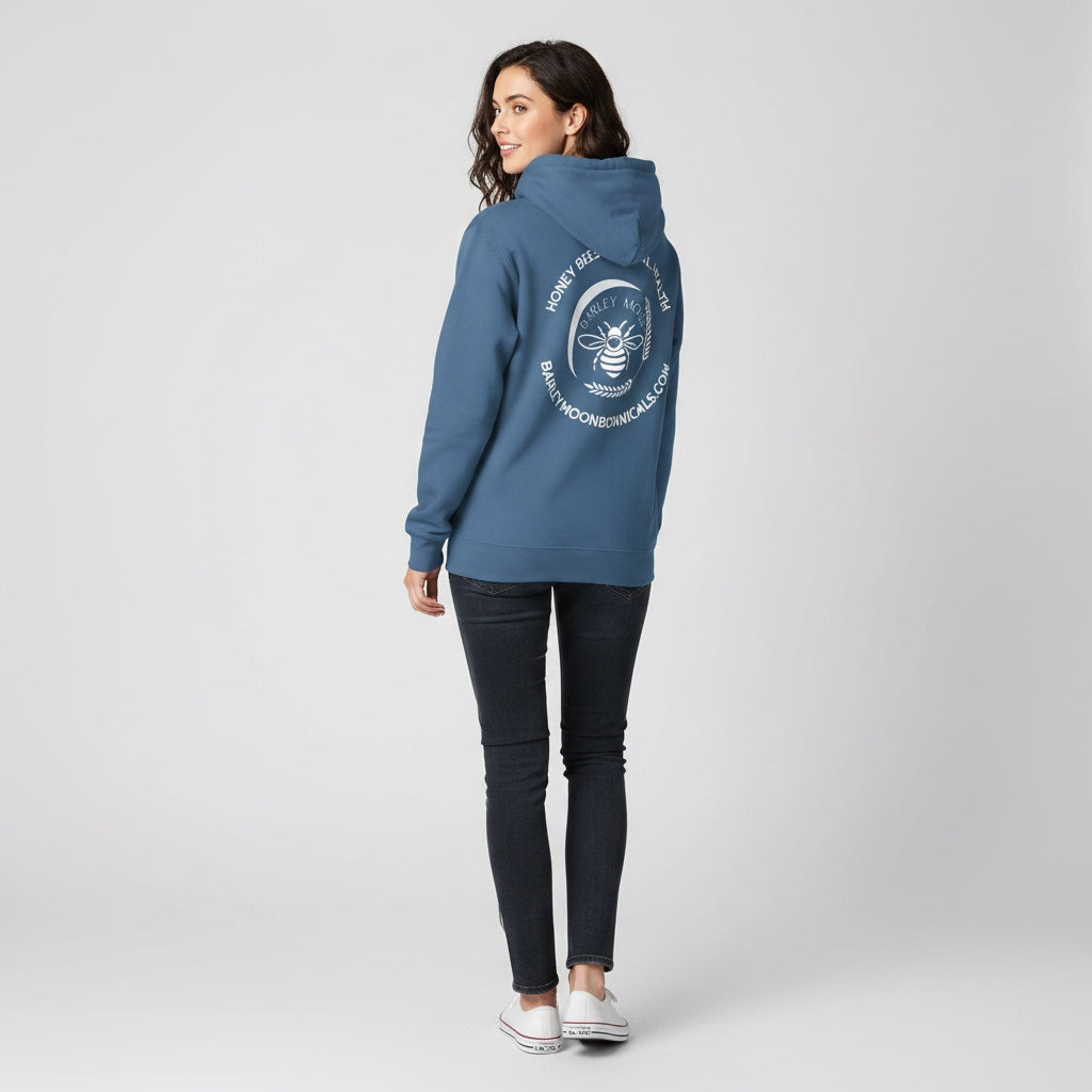 A woman wearing a blue Barley Moon Botanicals hoodie with a white bee and crescent moon logo on the back.