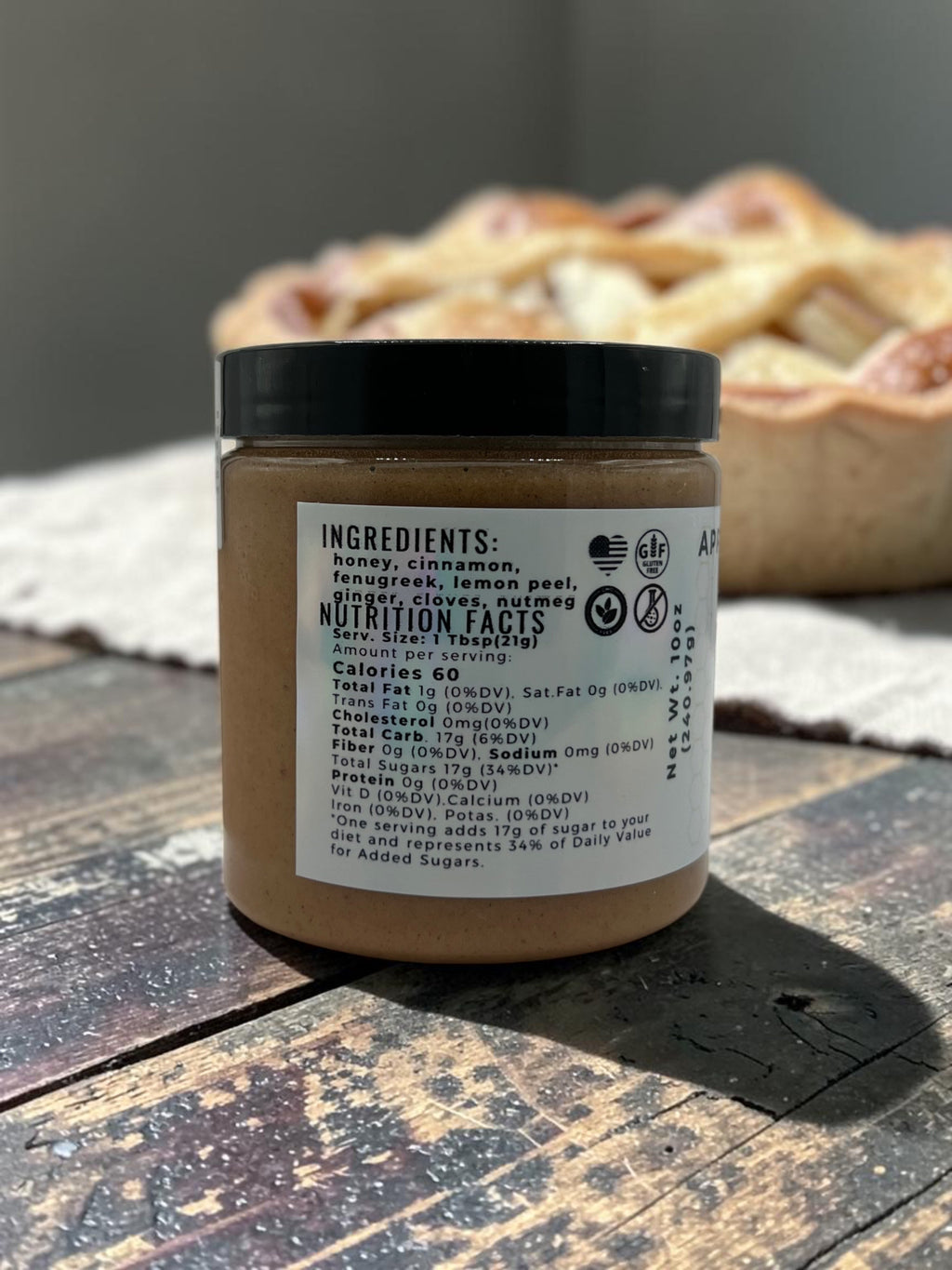 Barley Moon Botanicals Apple of My Hive creamed honey jar showing nutrition facts label with a pie in the background