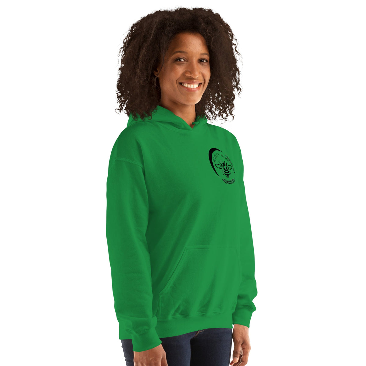 A woman wearing a bright green Barley Moon Botanicals unisex hoodie with a black bee and crescent moon logo.