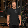 Man wearing a dark grey Barley Moon Botanicals t-shirt with a white bee and crescent moon logo in a gym setting.