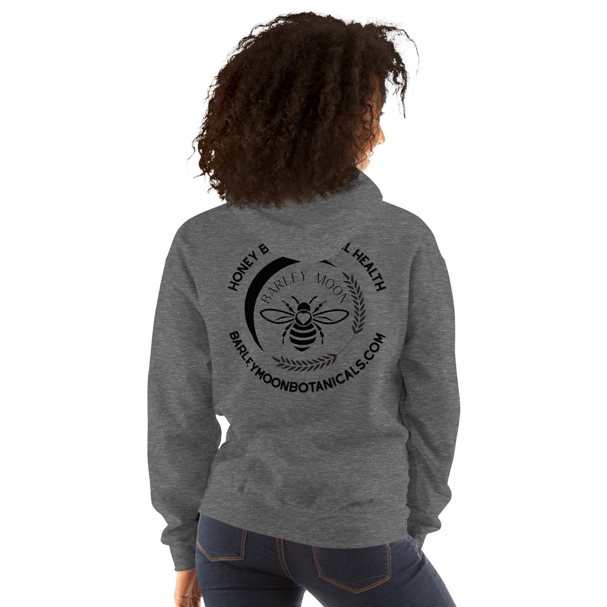 Woman wearing a grey Barley Moon Botanicals unisex hoodie featuring a black bee and crescent moon logo on the back.