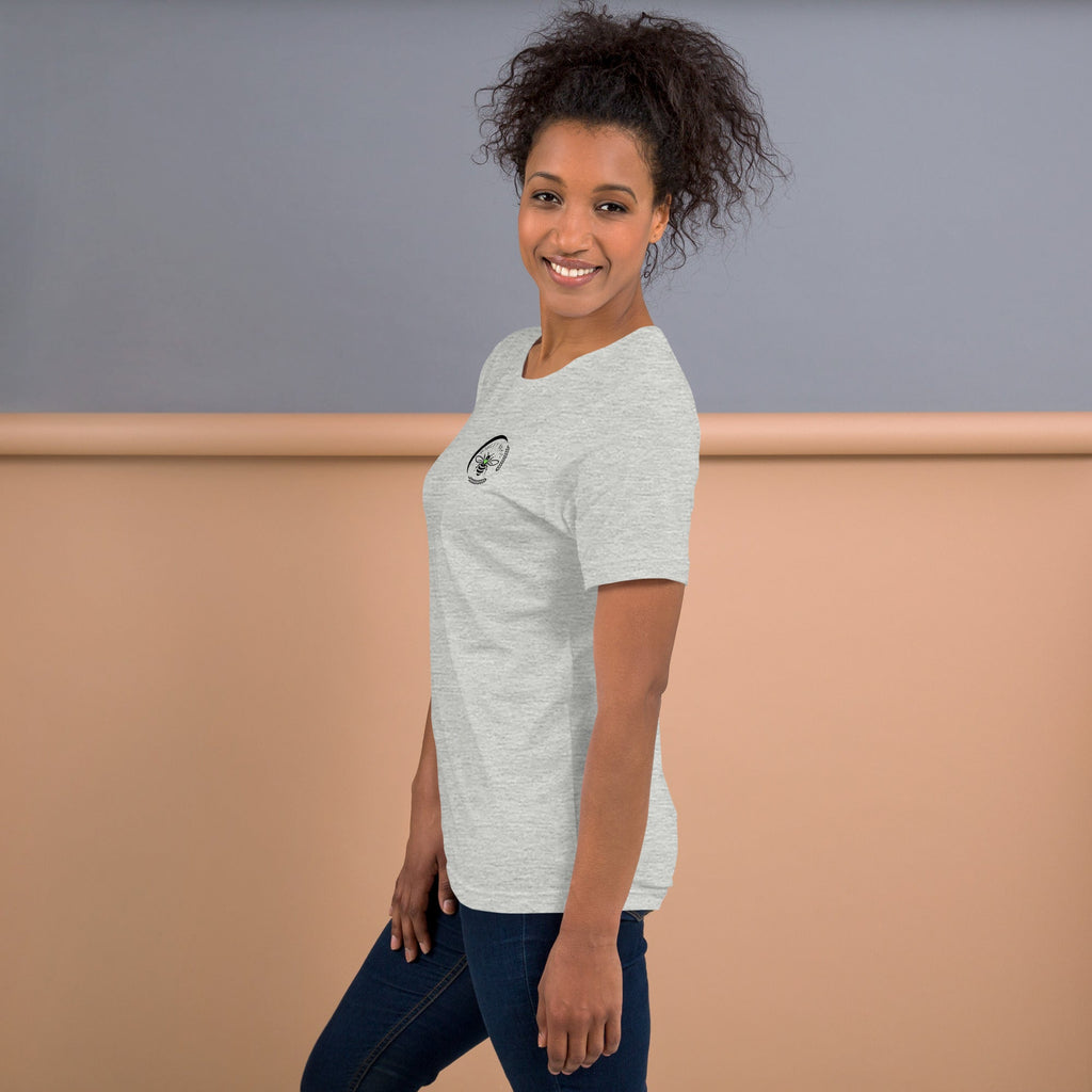 A woman wearing a grey Barley Moon Botanicals t-shirt with a black bee and crescent moon logo on the chest.