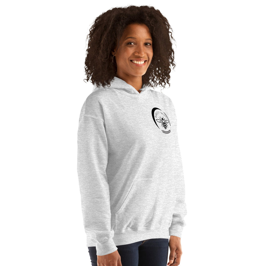 Woman wearing a Barley Moon Botanicals light grey unisex hoodie with a bee and crescent moon logo on the chest