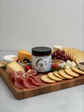 Barley Moon Botanicals Heated Hugs Habanero Honey jar centered on a gourmet charcuterie board with meats and cheeses.