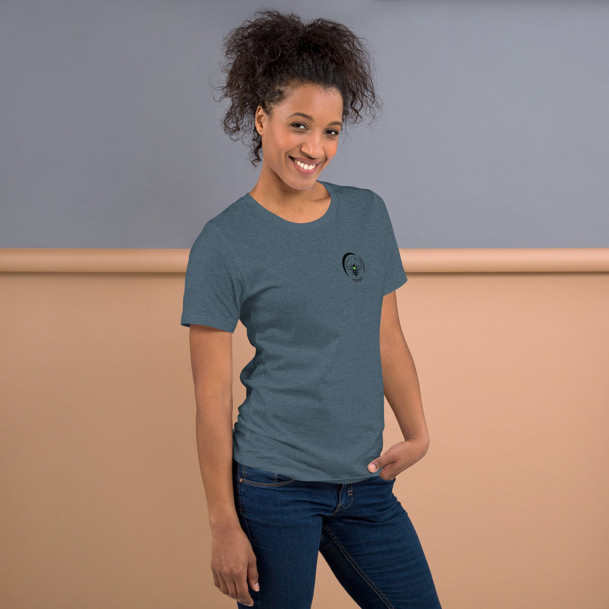 Barley Moon Botanicals heather blue t-shirt with bee and crescent moon logo worn by a smiling woman