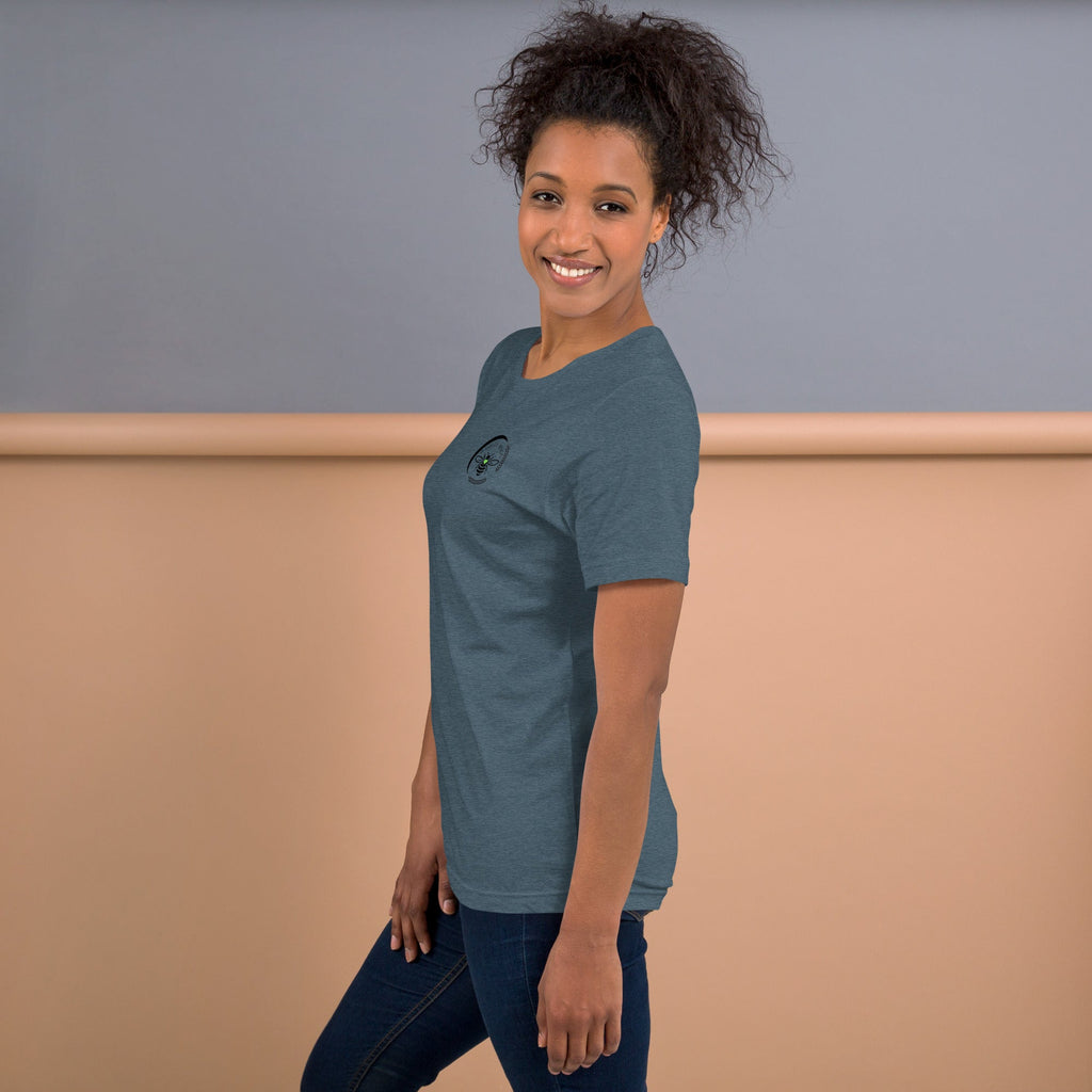 A woman wearing a Barley Moon Botanicals heather blue cotton t-shirt with a small bee and crescent moon logo.