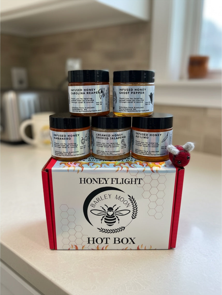 Barley Moon Botanicals Hot Box Honey Flight featuring five jars of spicy infused honey in a red gift box with a felt bee