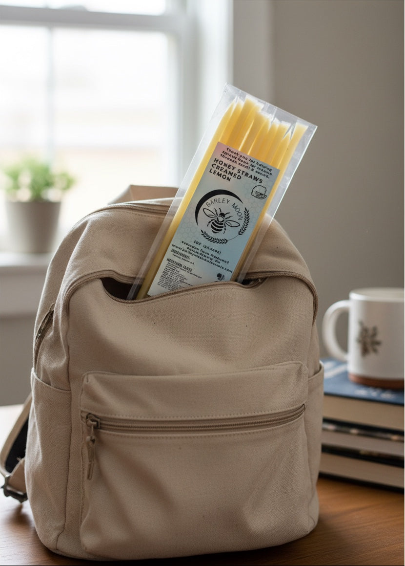 Barley Moon Botanicals lemon creamed honey straws in a clear pack tucked into a beige canvas backpack on a desk