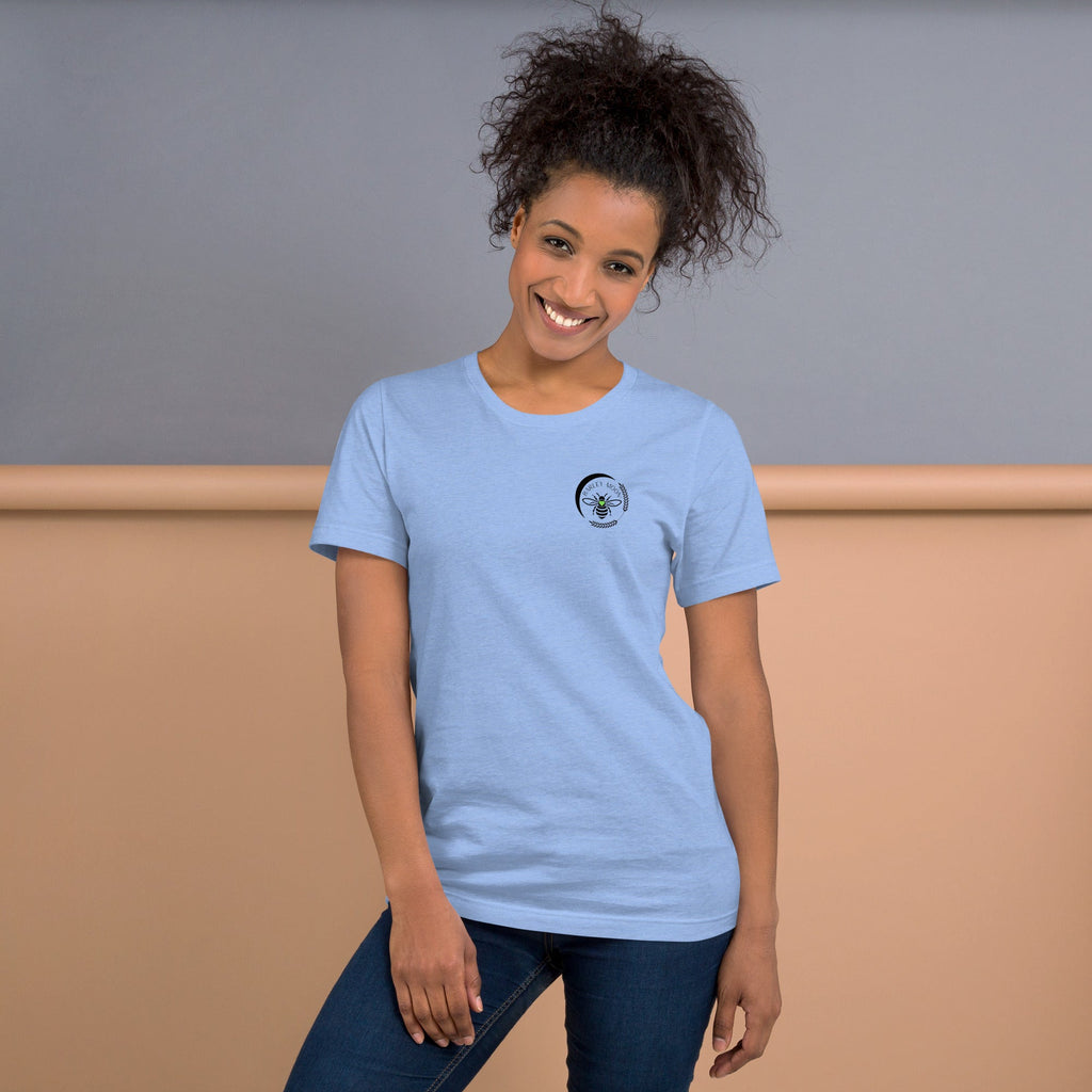 A woman wearing a light blue Barley Moon Botanicals t-shirt with a black bee and crescent moon logo on the chest.