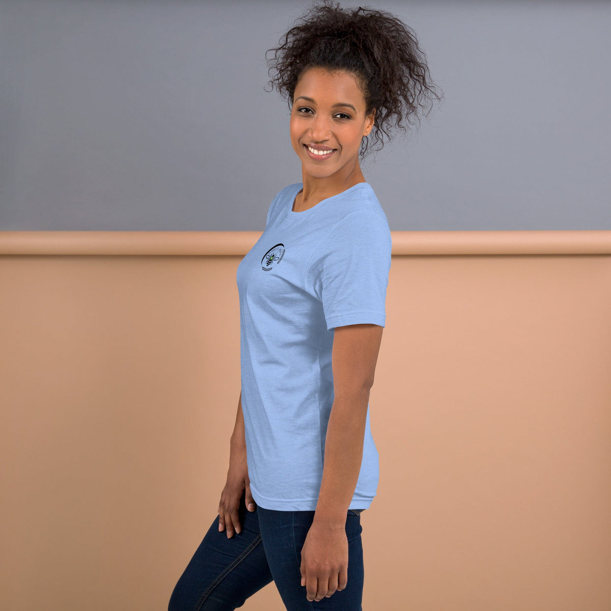 A woman wearing a light blue Barley Moon Botanicals t-shirt with a bee and crescent moon logo on the chest.