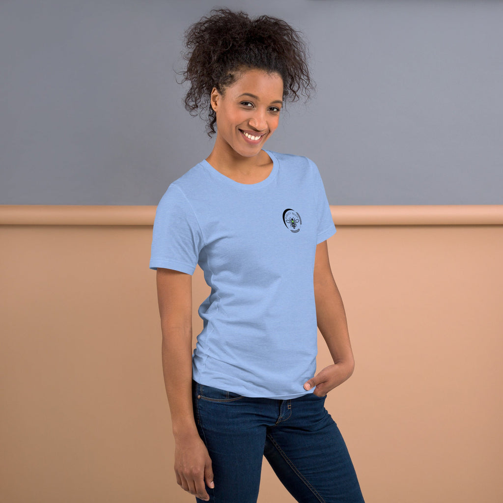 A smiling woman wearing a light blue Barley Moon Botanicals t-shirt with a black bee and crescent moon logo.