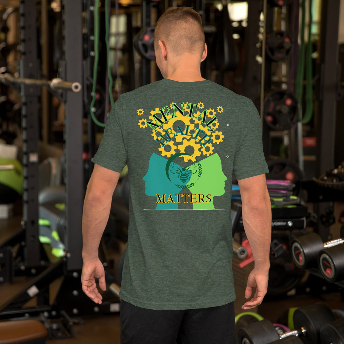 A man wearing a Barley Moon Botanicals olive green cotton t-shirt with a mental health graphic in a gym setting.