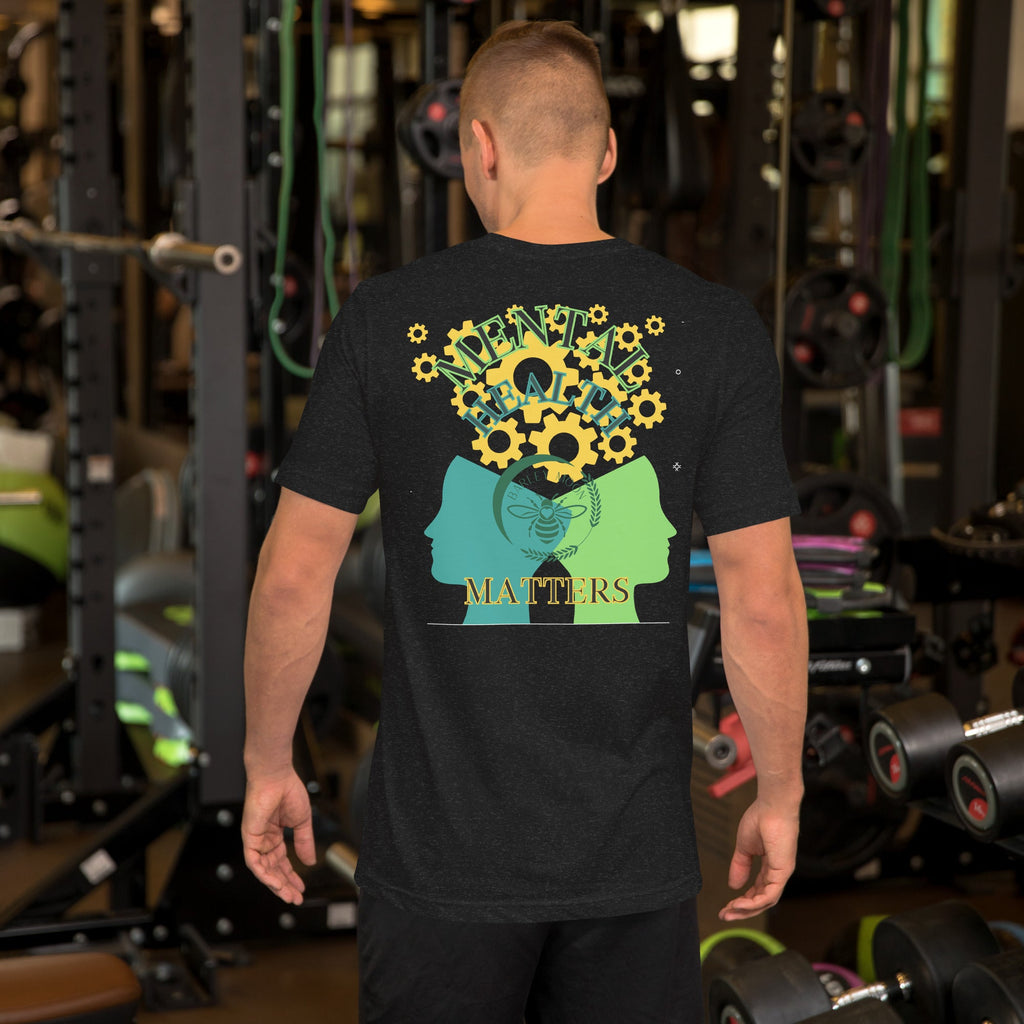 Back view of a man wearing a Barley Moon Botanicals black unisex t-shirt with a mental health graphic in a gym.