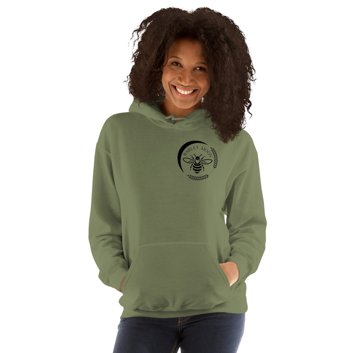 Woman wearing a Barley Moon Botanicals olive green unisex hoodie with a black bee and crescent moon logo on the chest.