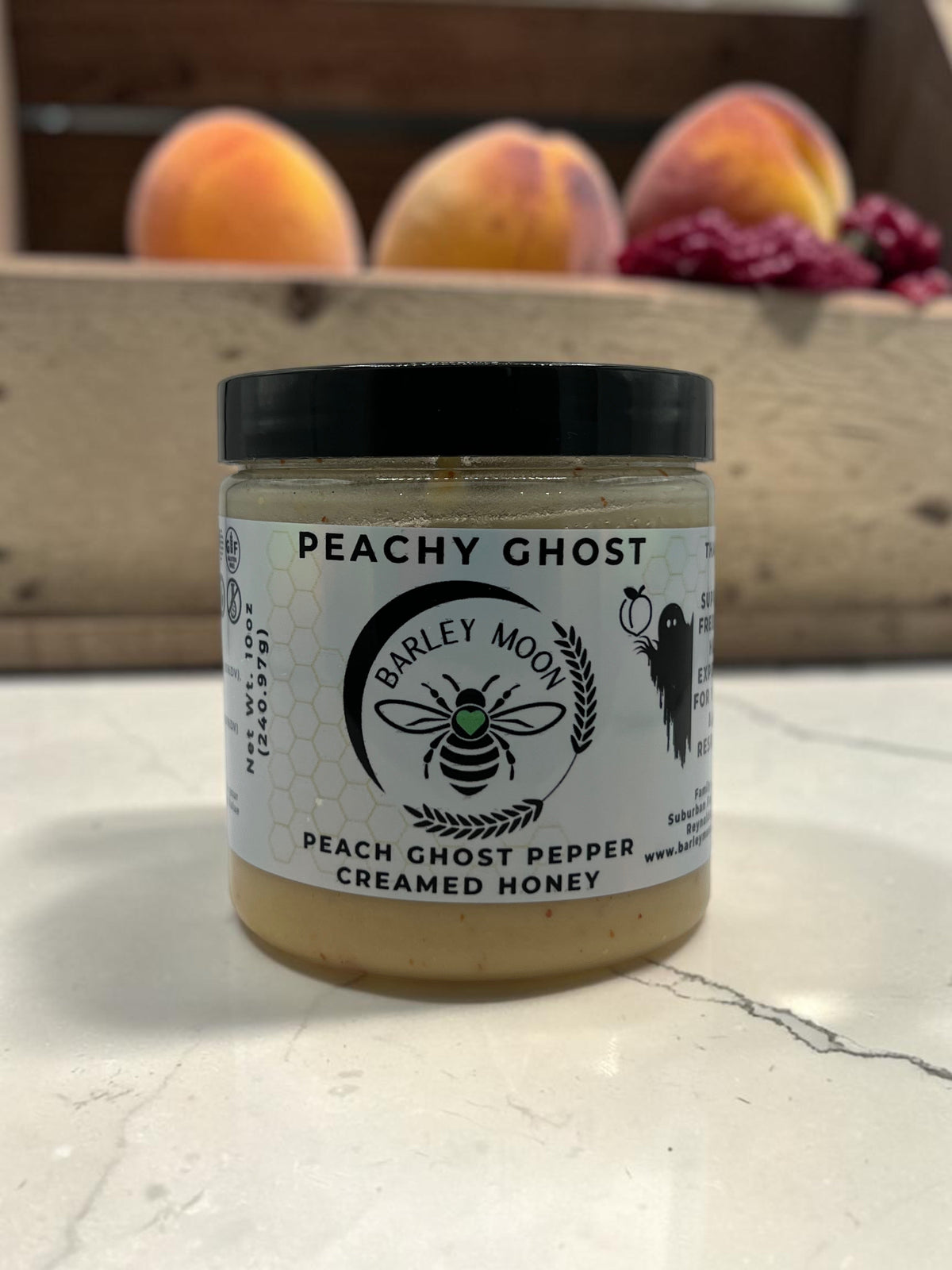 Barley Moon Botanicals Peachy Ghost creamed honey jar with peach ghost pepper in a clear glass container