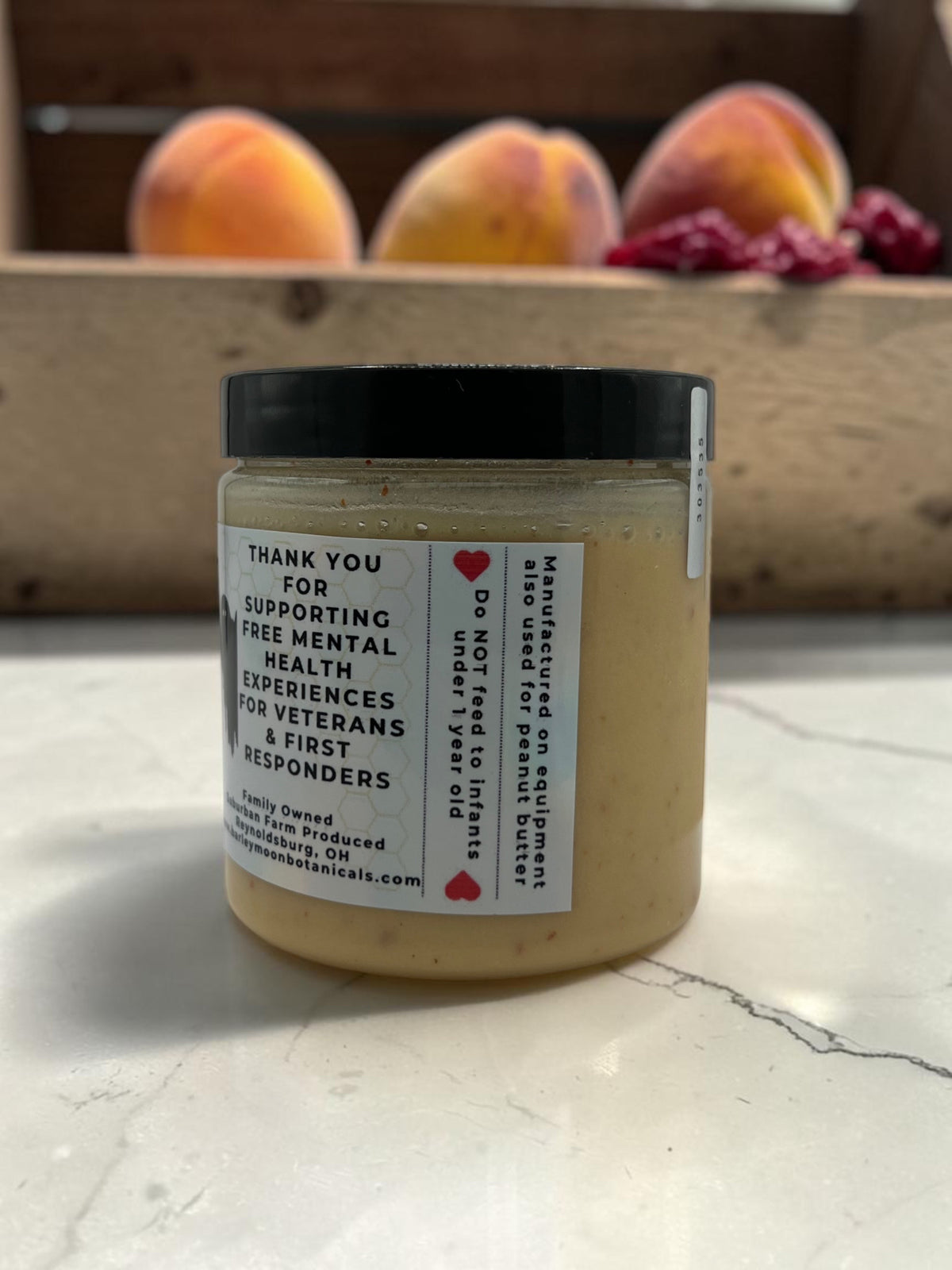 Barley Moon Botanicals Peachy Ghost creamed honey jar with peach and ghost peppers on a marble countertop