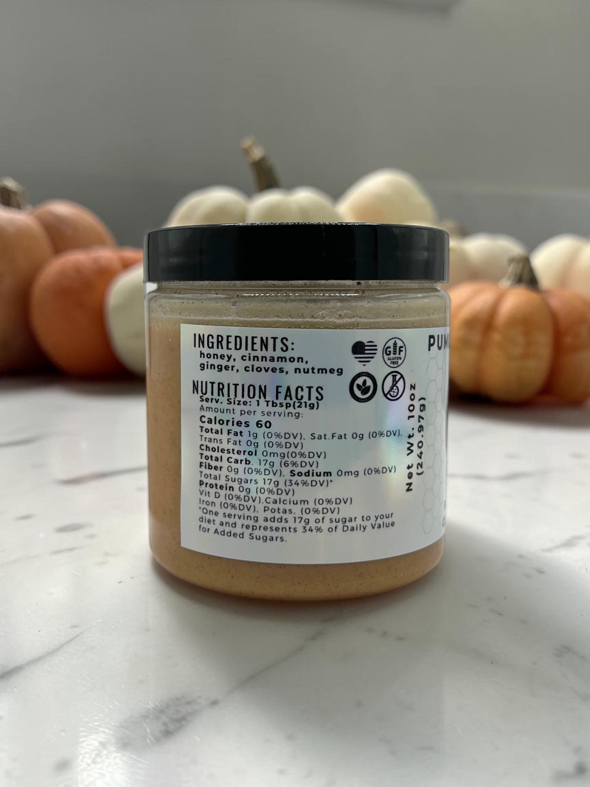Barley Moon Botanicals Pumpkin Promise creamed honey jar showing nutrition facts label with fall pumpkins in background