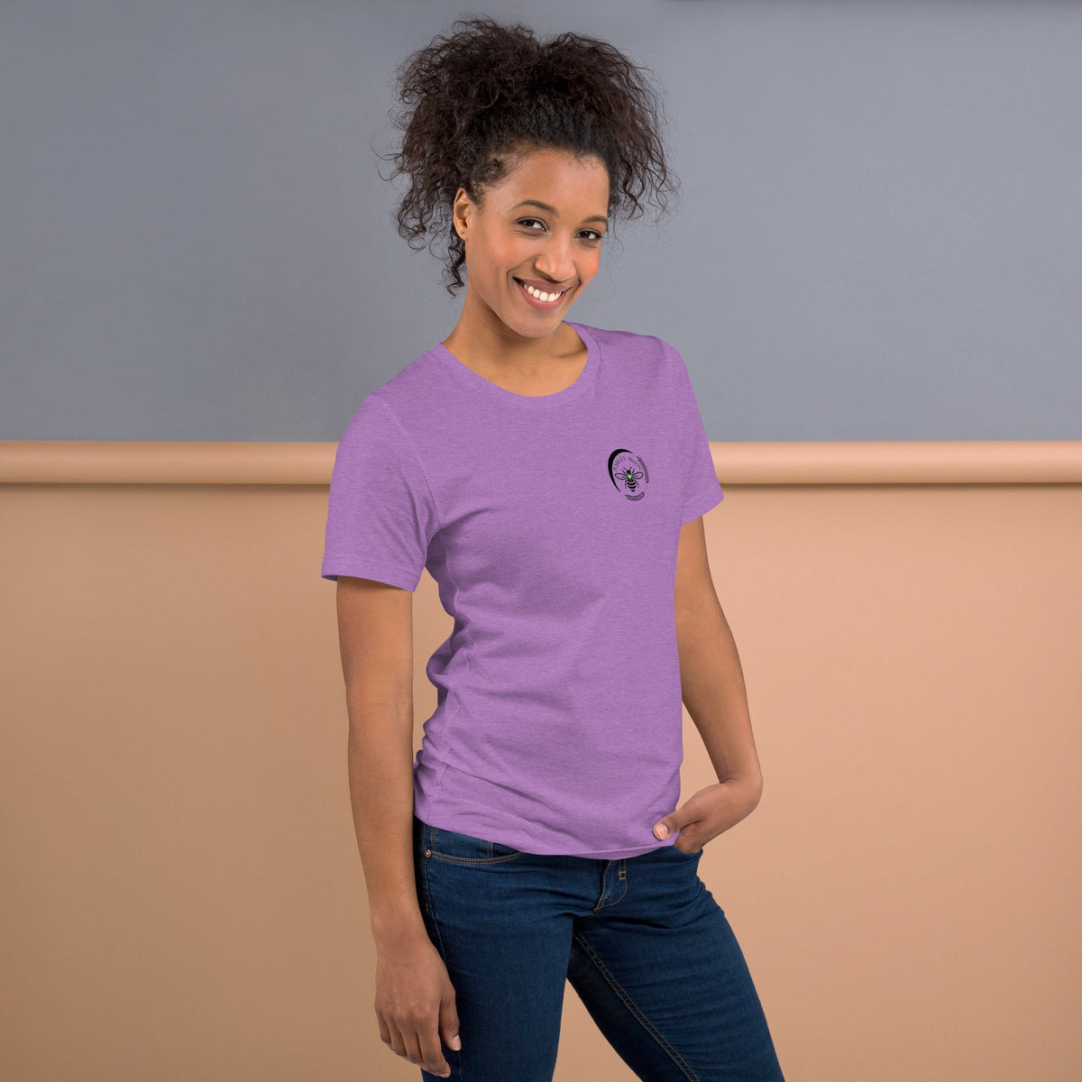 A woman wearing a Barley Moon Botanicals purple cotton t-shirt with a black bee and crescent moon logo on the chest.