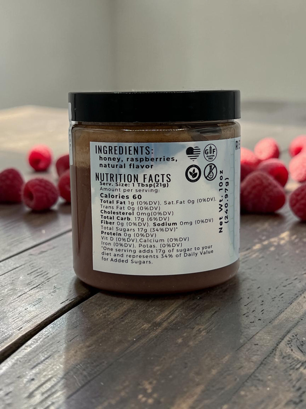 Barley Moon Botanicals Regal Razzle raspberry creamed honey jar showing nutrition facts label with fresh raspberries
