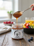 Barley Moon Botanicals Regal Razzle raspberry creamed honey being drizzled from a spoon over a breakfast table