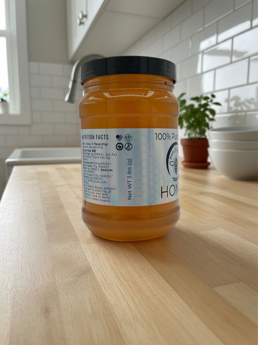 Barley Moon Botanicals 3lb jar of pure raw local honey with nutrition label on a wooden kitchen counter
