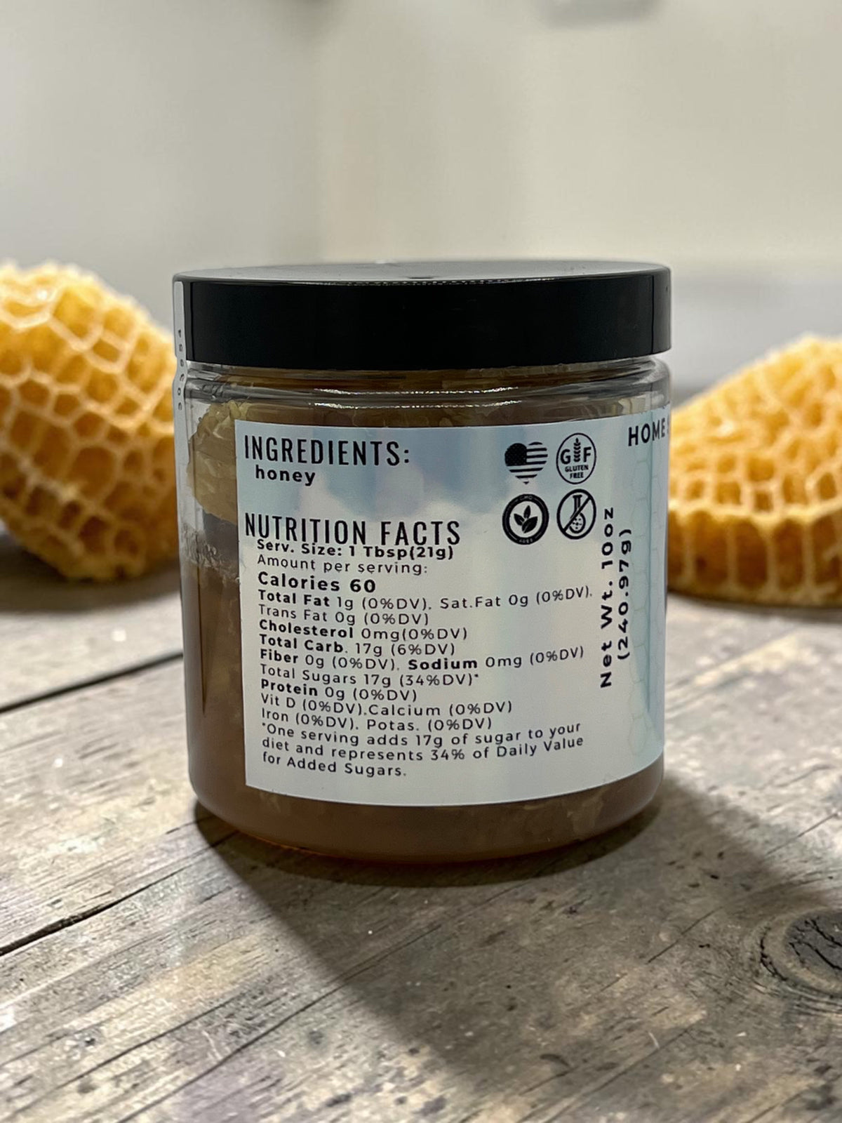 Barley Moon Botanicals raw honeycomb jar showing nutrition facts label on a rustic wooden table with honeycomb pieces