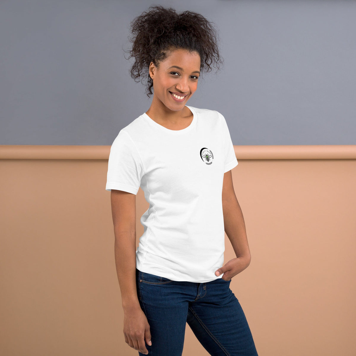 Woman wearing a white Barley Moon Botanicals t-shirt with a small black bee and crescent moon logo on the chest.