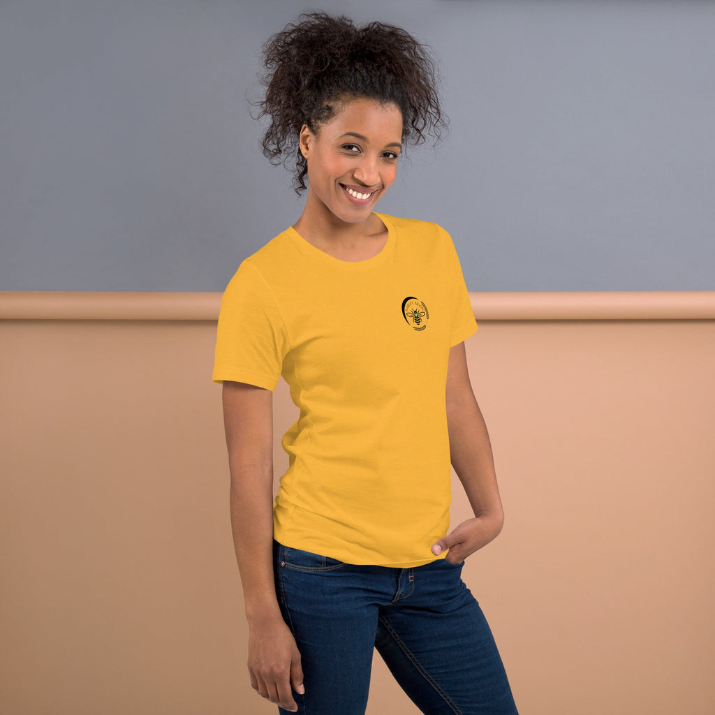 A woman wearing a yellow Barley Moon Botanicals cotton t-shirt with a black bee and crescent moon logo on the chest.