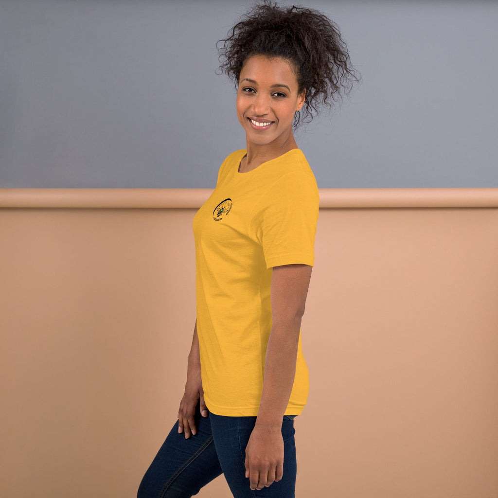 A woman wearing a yellow Barley Moon Botanicals t-shirt with a black bee and crescent moon logo on the chest.